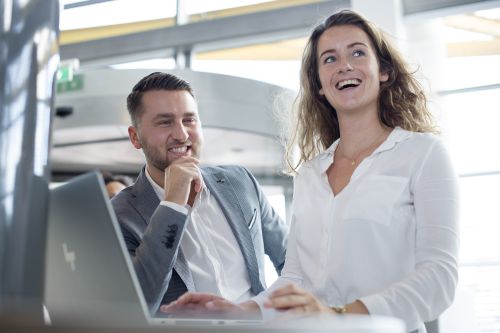 man en vrouw lachen samen als collega's